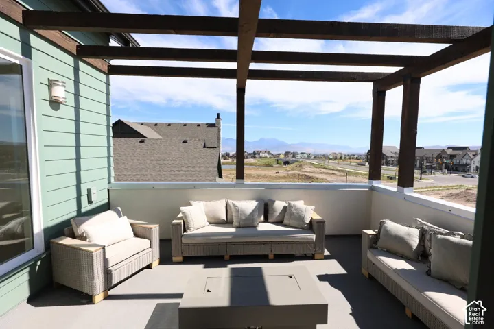 Rooftop deck featuring a wood pergola, solid railings, outdoor lighting fixture, and a sliding glass door
