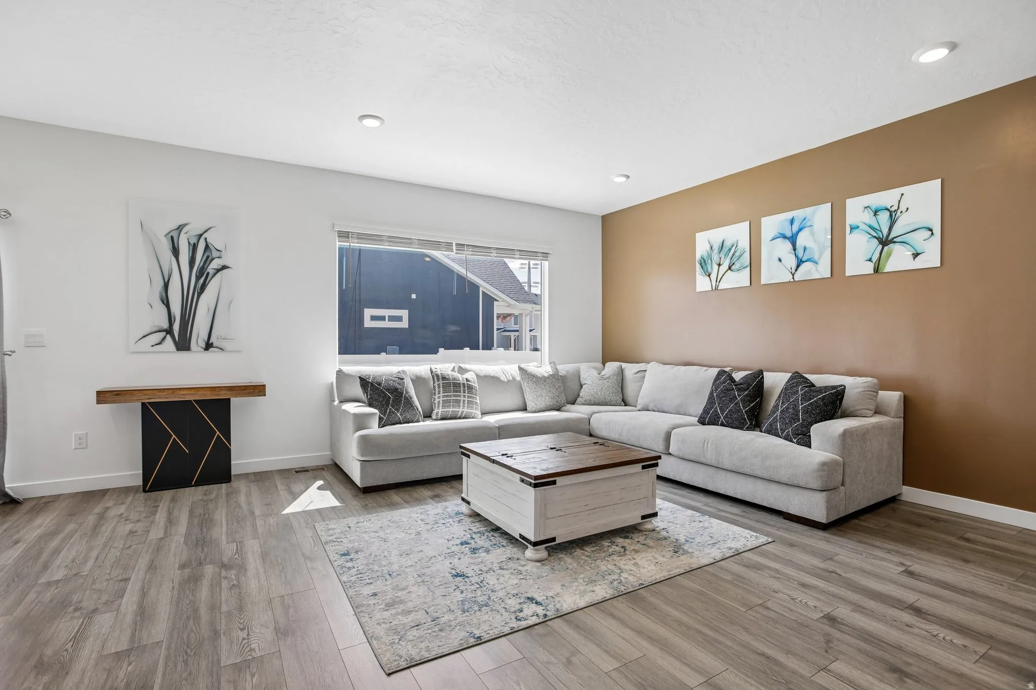 Recessed lighting, wood-finish flooring, and a large window with blinds