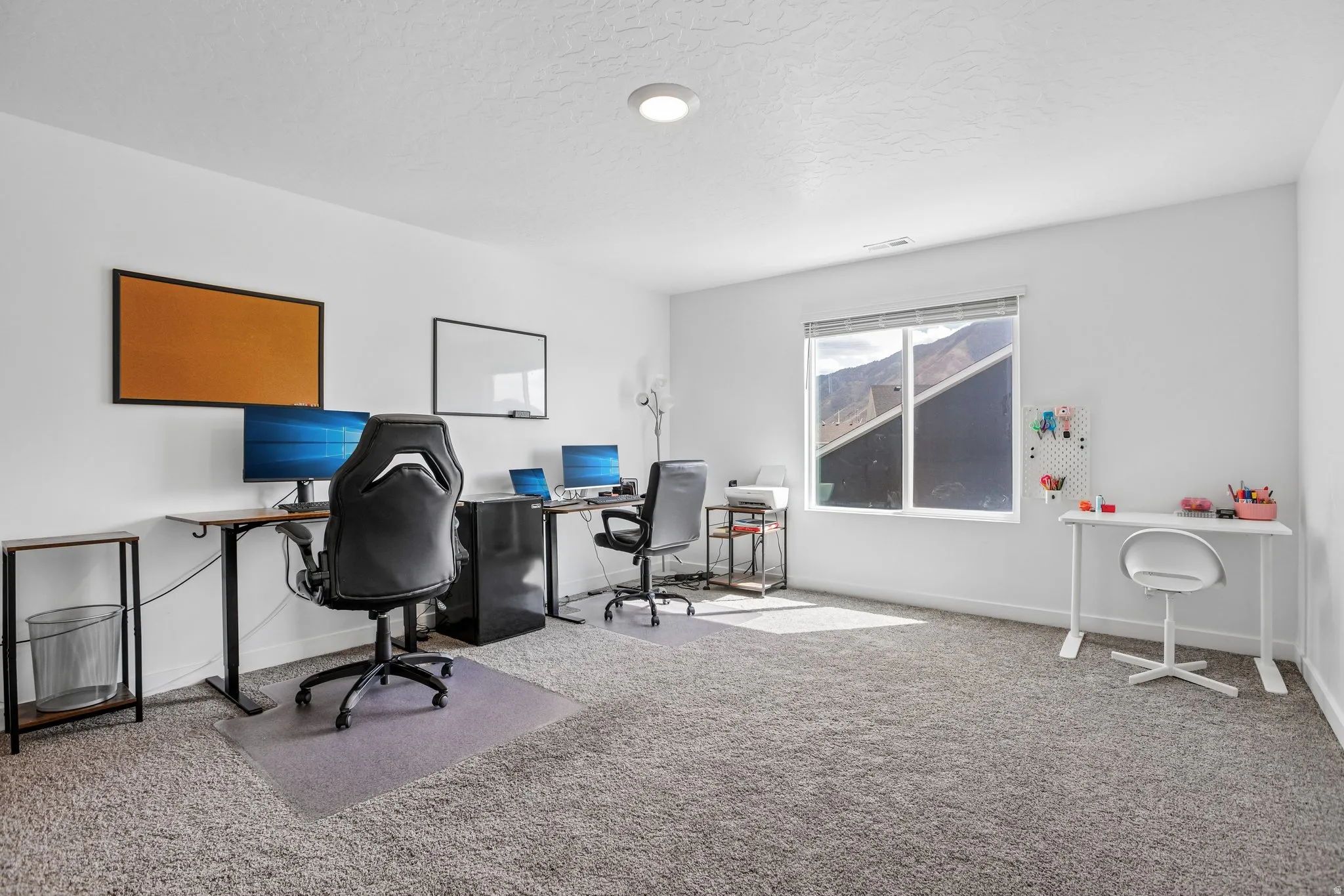 Carpeted room with white walls, a large window, and recessed lighting