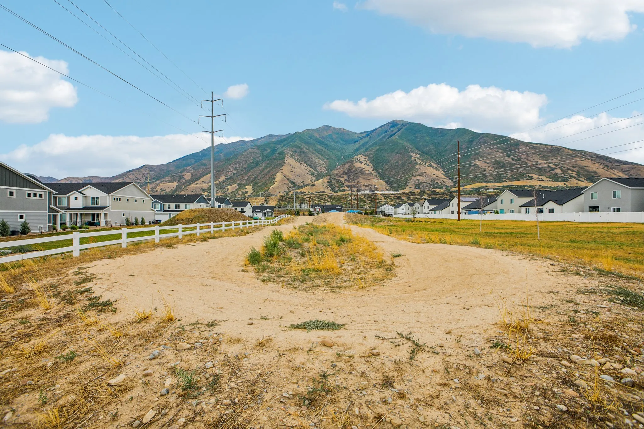 Mountain backdrop with residential properties and open land