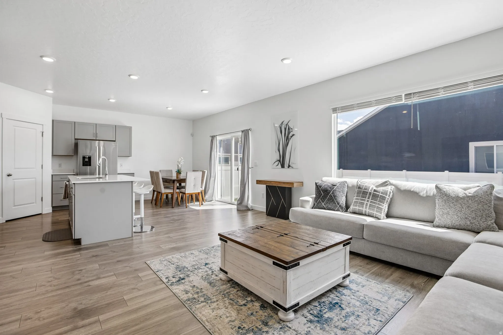 Open concept living area featuring wood-finish flooring, recessed lighting, and large windows