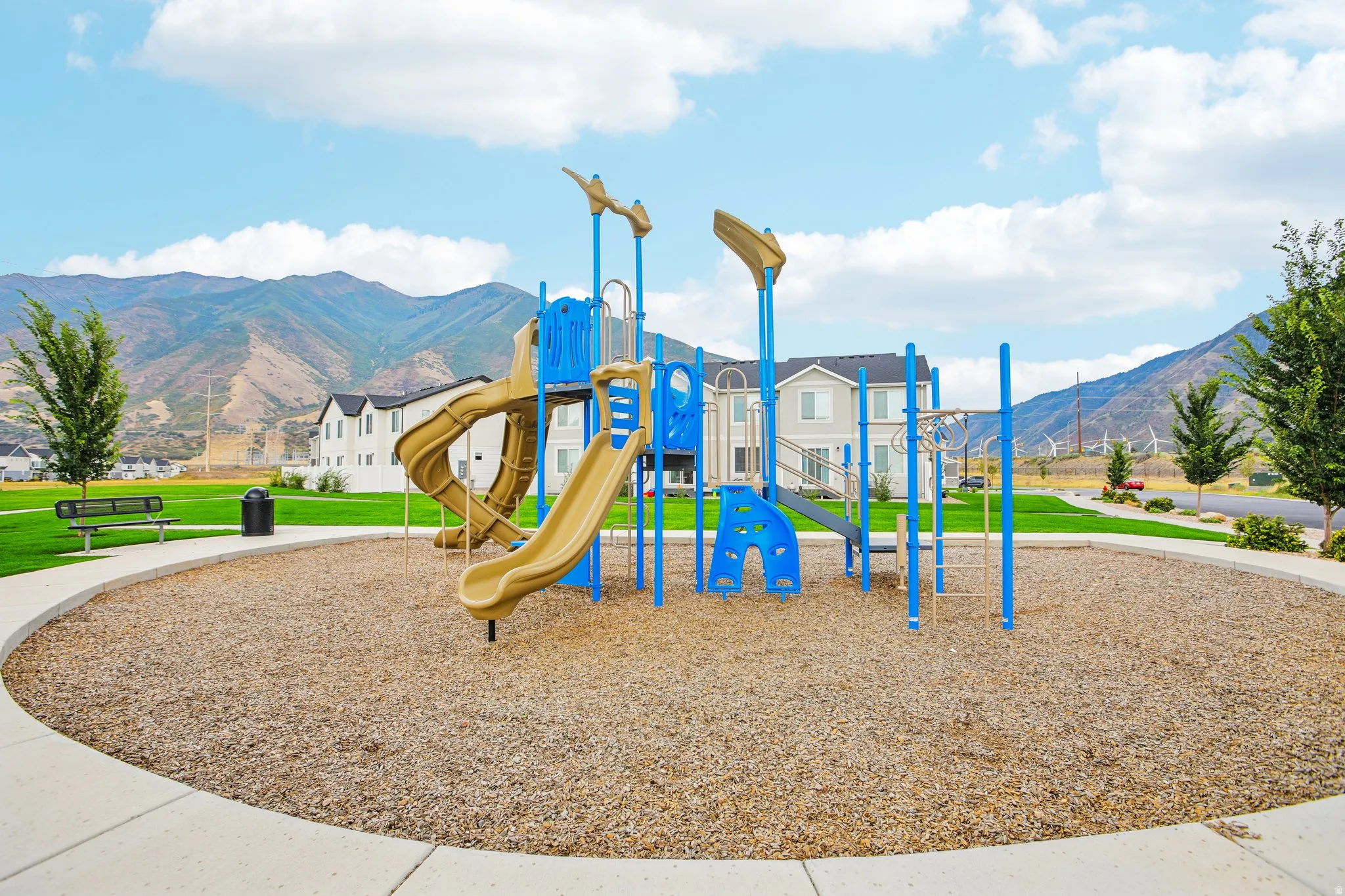 Playground structure with slides, climbing elements, and protective ground cover