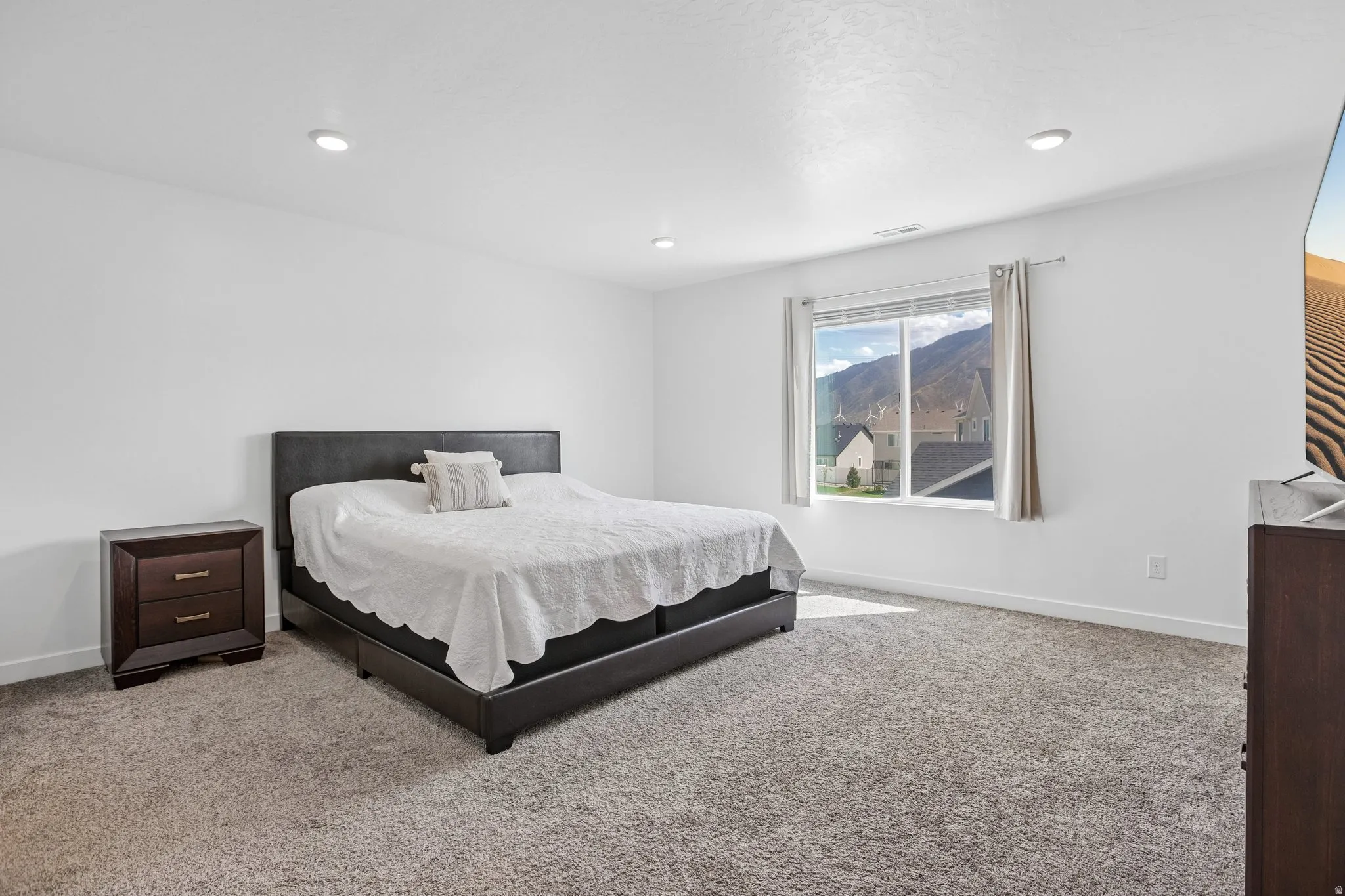 Recessed ceiling lighting, white wall finishes, and a window with mountain scenery