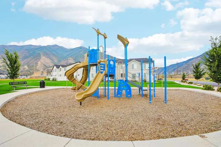 Playground structure with slides, climbing elements, and protective ground cover