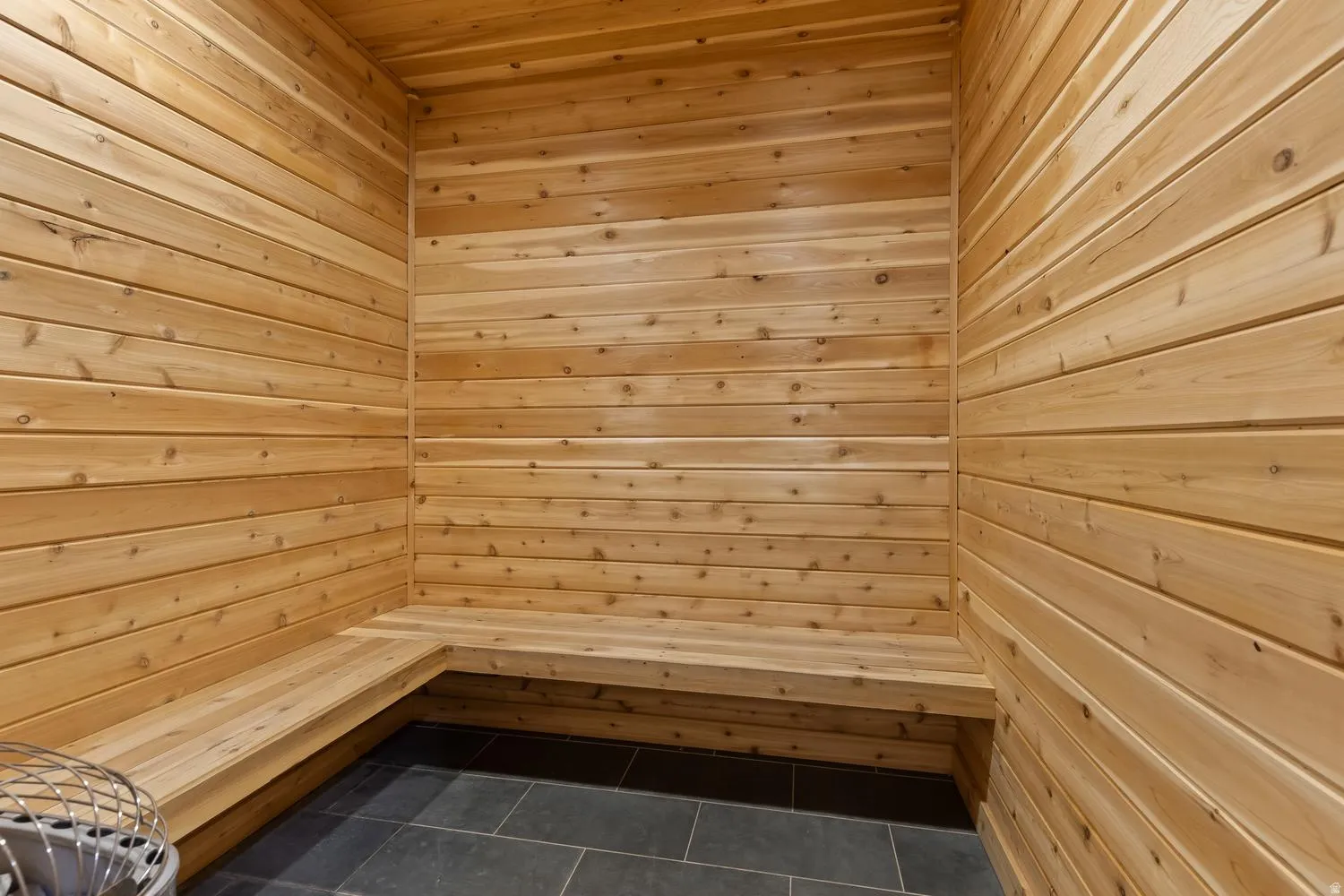 Wood-paneled walls and ceiling with integrated wood bench seating and dark tile flooring
