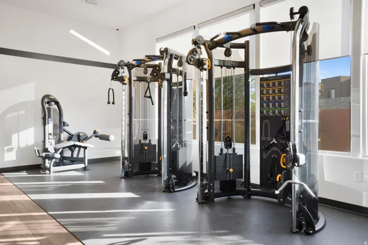 Gym space featuring high ceilings, rubberized flooring, and large windows
