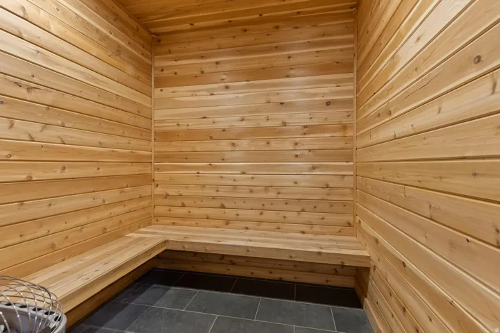 Wood-paneled walls and ceiling with integrated wood bench seating and dark tile flooring
