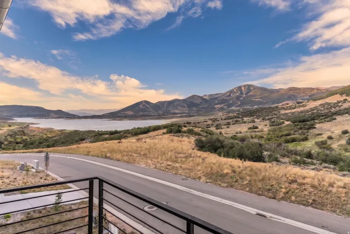 Expansive mountain and lake scenery from a contemporary balcony with black metal railings