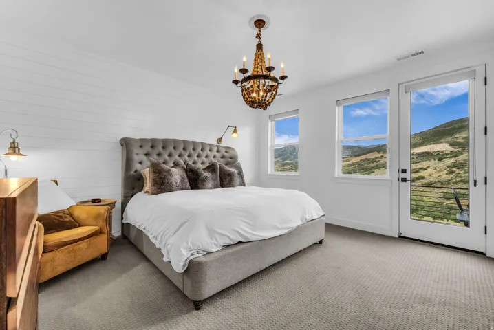 White shiplap accent wall with a tufted upholstered headboard and integrated sconce lighting