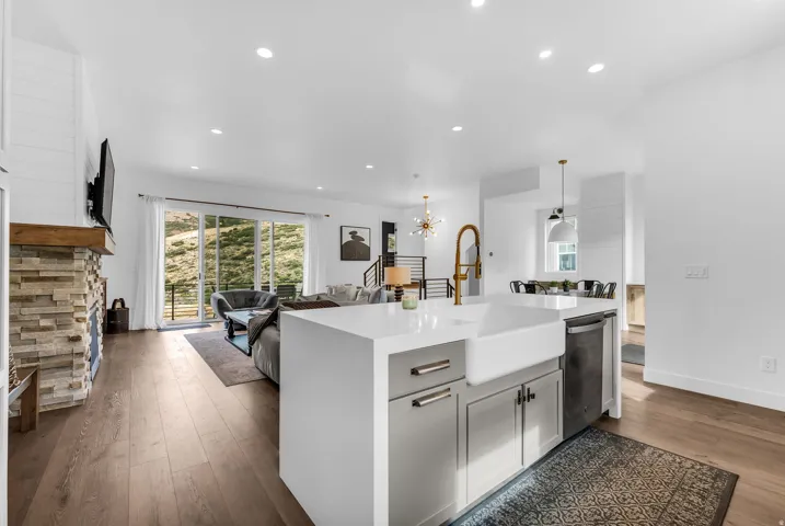 Spacious kitchen island with an integrated farmhouse sink, white countertops, and a modern gold-toned faucet
