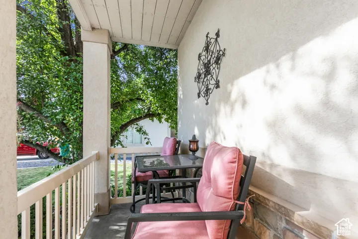 Covered porch featuring stucco walls, a wood plank ceiling, and a decorative railing