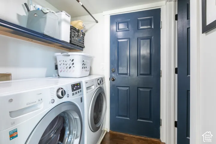 Dedicated laundry area featuring a built-in shelf and dark wood-finish flooring located right off dining room area.