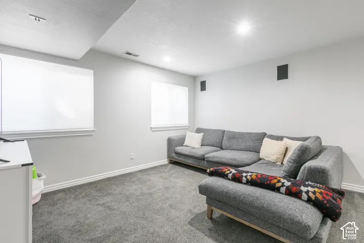 Recessed lighting illuminates this space featuring gray carpeting and white walls