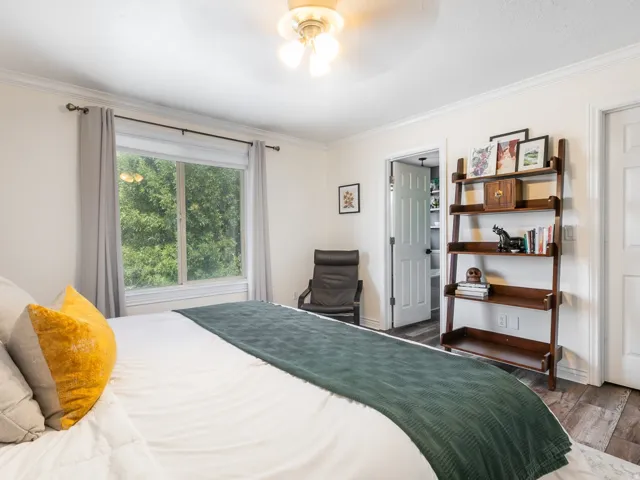 Expansive window with natural light, wood-finish flooring, crown molding,