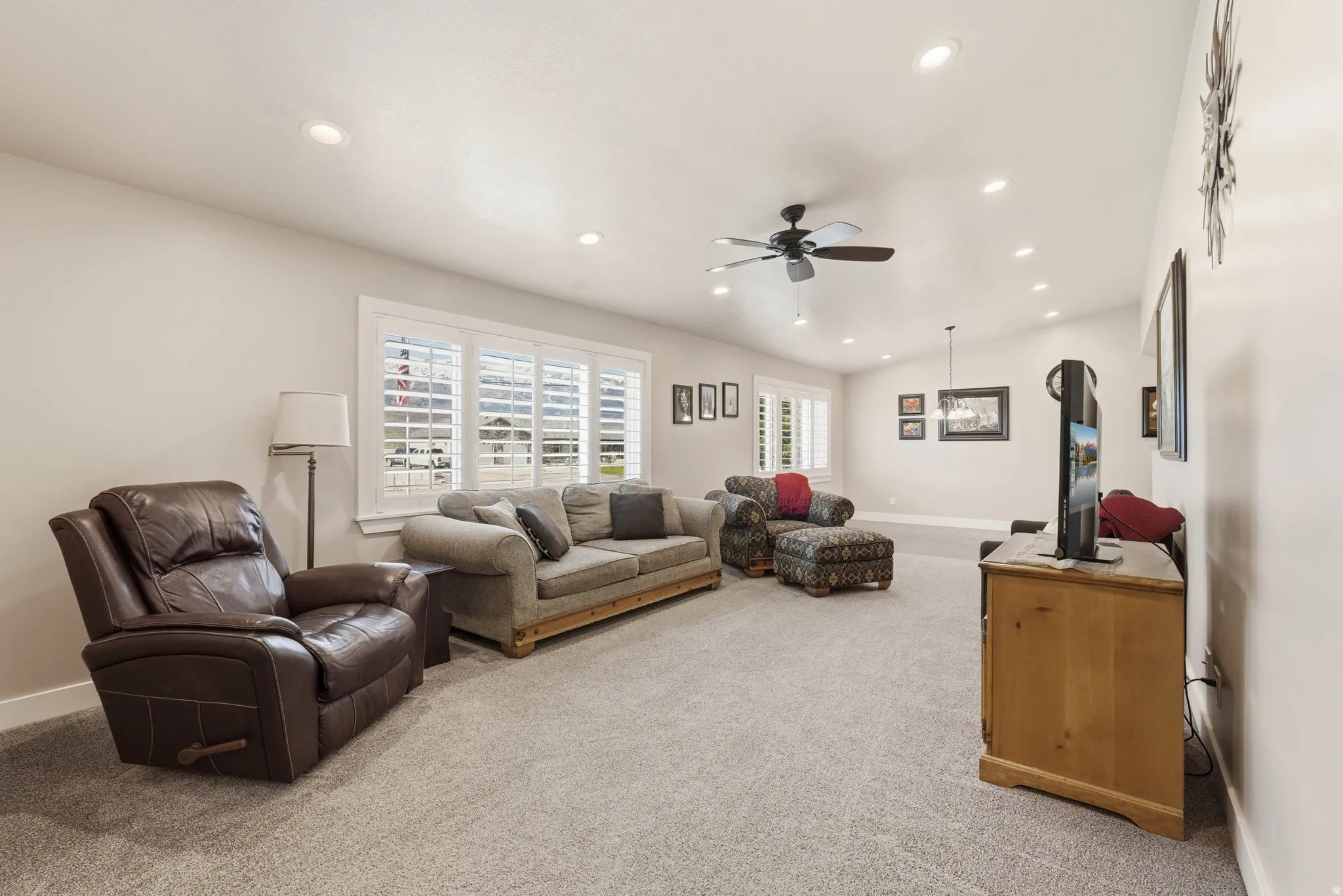 Recessed lighting, vaulted ceiling, multi-pane windows, ceiling fan, and light-toned carpet