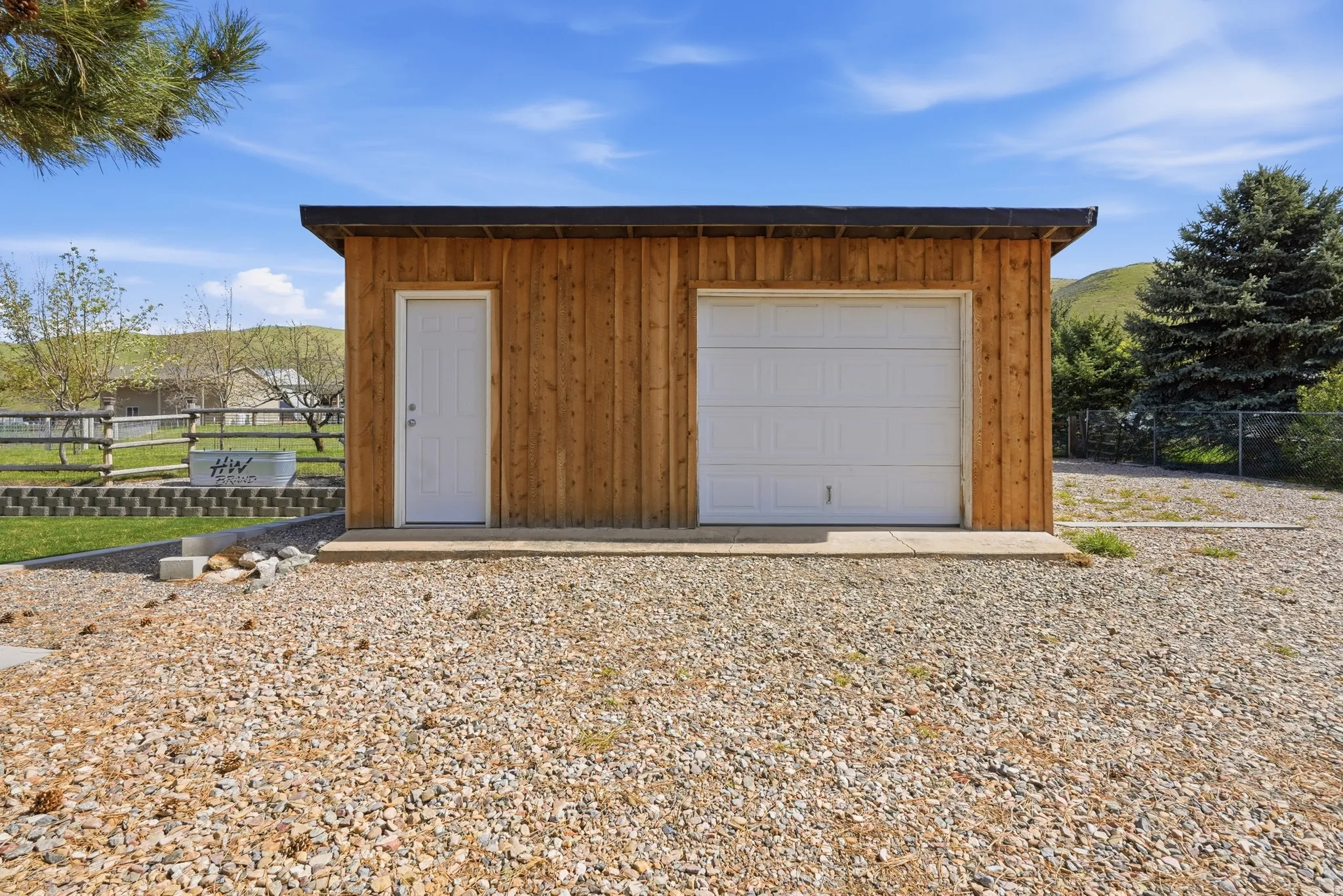 Wood-sided outbuilding with single garage door and separate pedestrian entry
