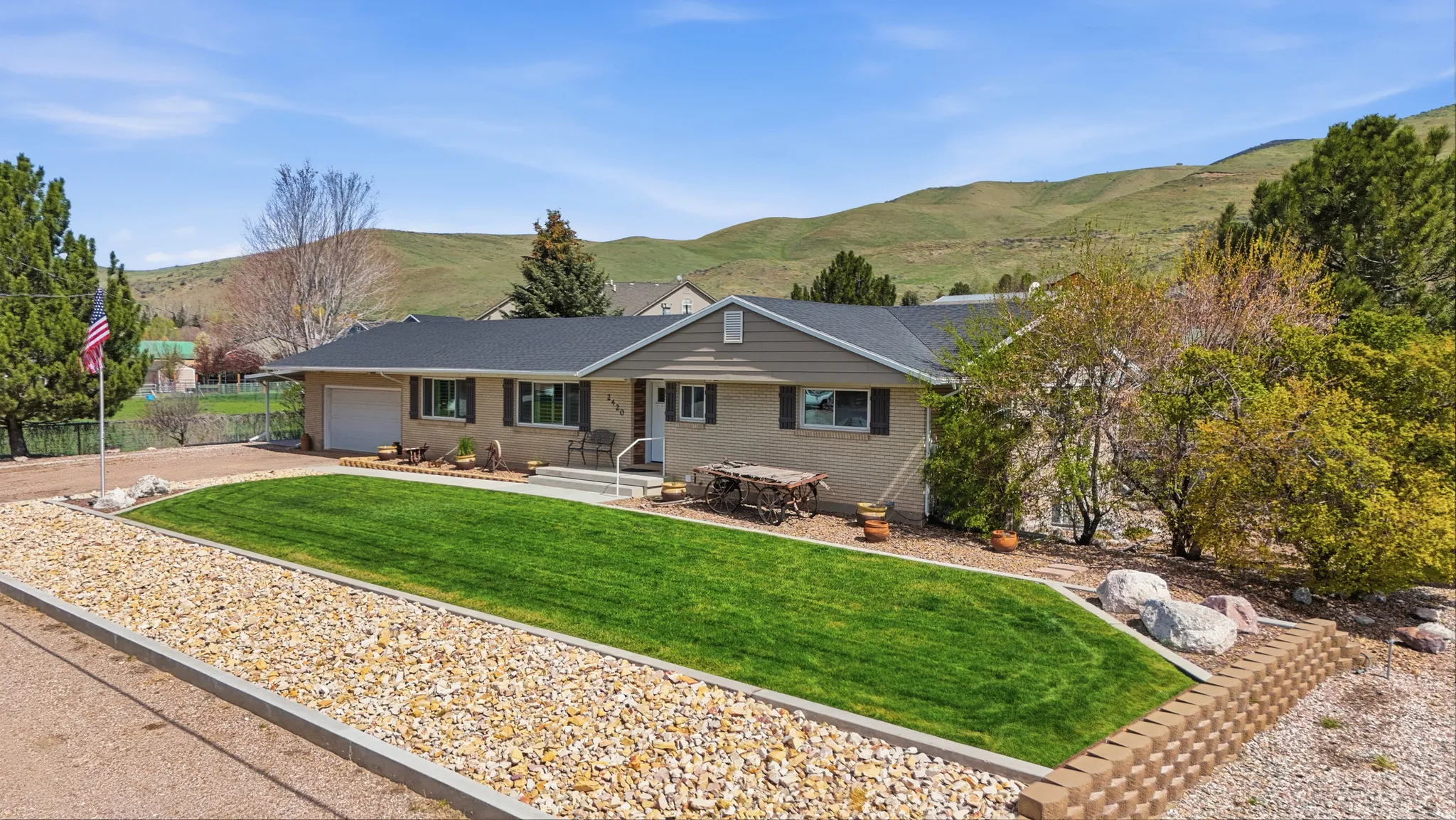 Ranch-style residence featuring a dark shingle roof, attached garage, and light-toned exterior siding