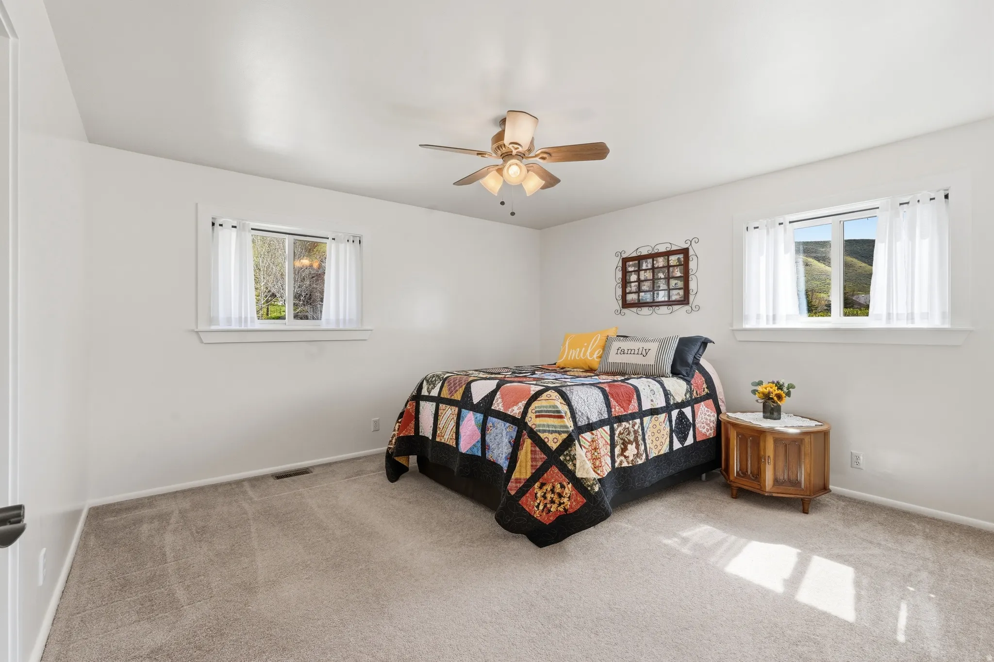 Recessed windows with sill, ceiling fan with light fixture, and wall-to-wall carpeting