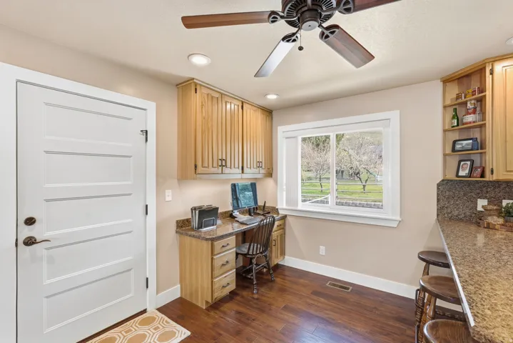 Built-in desk area with wood-finish cabinetry, recessed lighting, and a large window