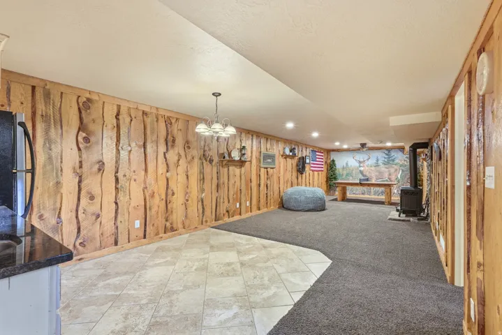 Wood-paneled accent walls, recessed lighting, tile flooring, and dark carpet