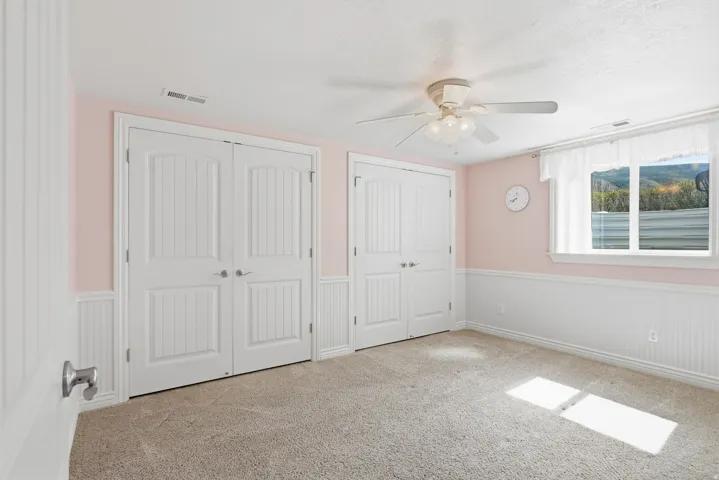 Carpeted flooring with white wainscoting and light pink walls