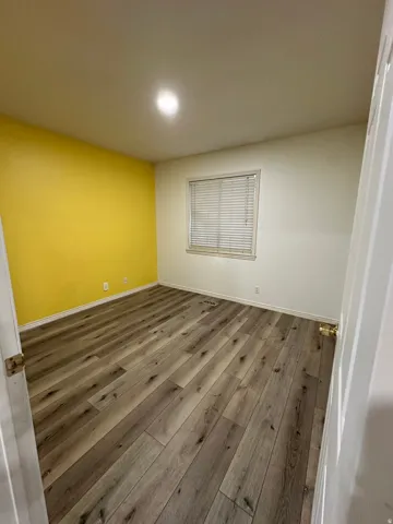 Wood-finish flooring, recessed ceiling light, and a window with blinds