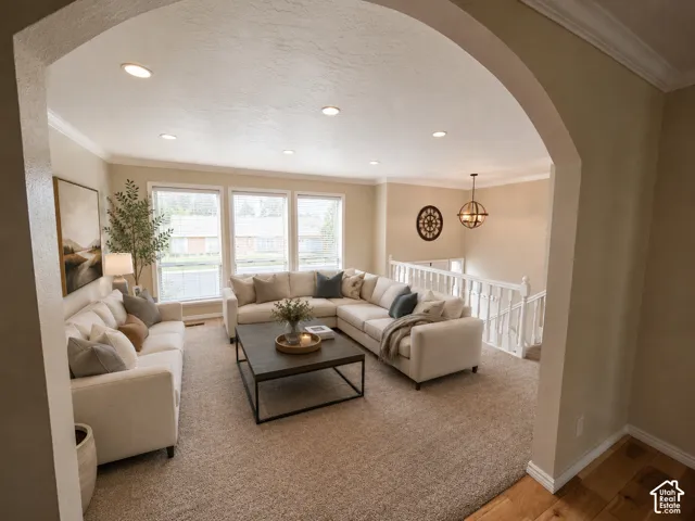 Archway entry into a living area featuring recessed lighting, a multi-pane window array, and crown molding