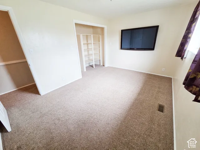 Carpeted interior space with light-toned walls and white trim