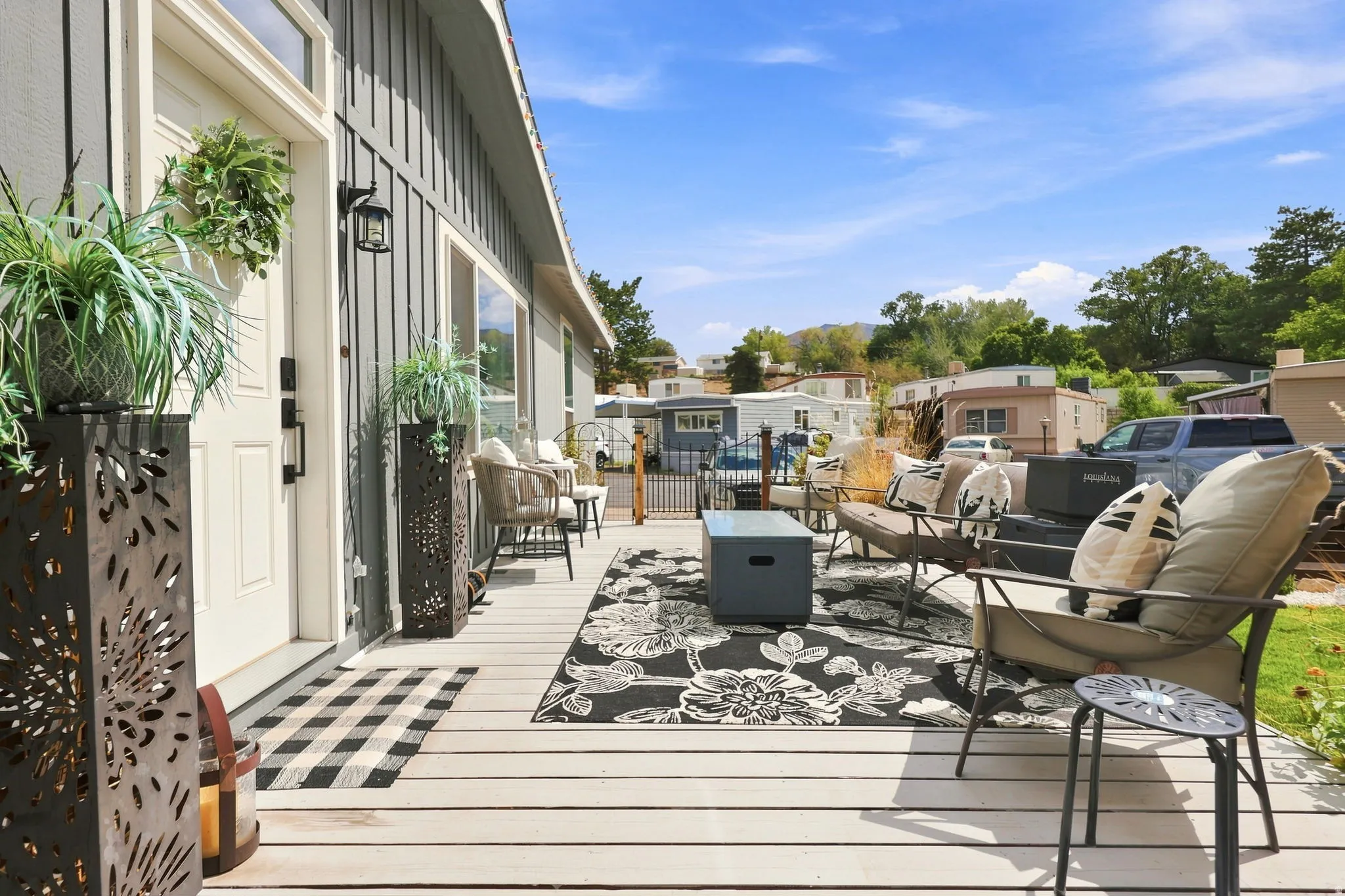 Expansive porch with light-toned decking, vertical panel siding, and multiple windows