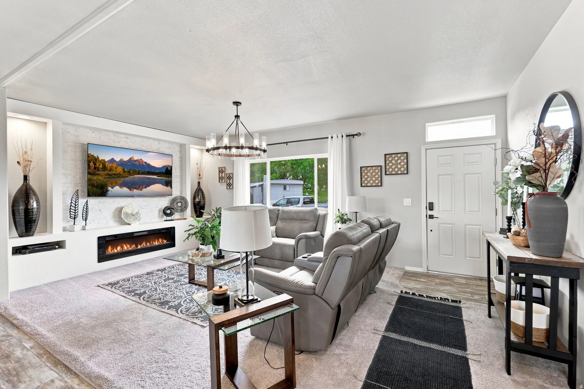 Built-in media center with an electric fireplace, recessed niches, and a textured accent wall