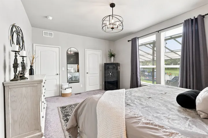 Two pane windows, ceiling light fixture, two interior doors, wall-mounted mirror, and wall-to-wall carpeting