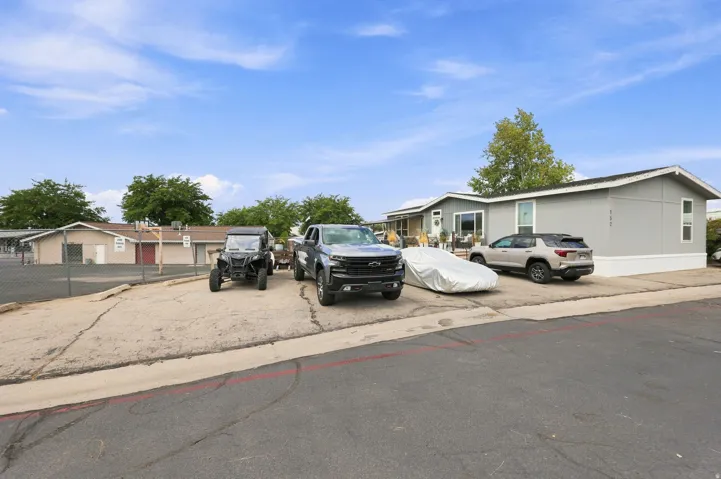 Property featuring a light gray exterior with white trim, a gabled roofline, and a paved driveway