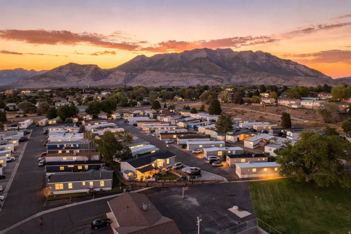 Expansive mountain backdrop with a community setting featuring multiple residences and paved roadways