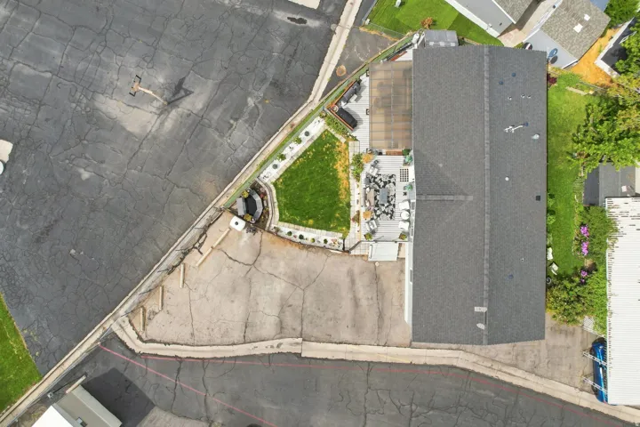Expansive paved outdoor area with integrated landscaping and a dedicated lawn space