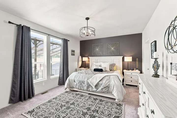 Recessed windows with blinds, carpeted flooring, a dark accent wall, and a ceiling-mounted light fixture