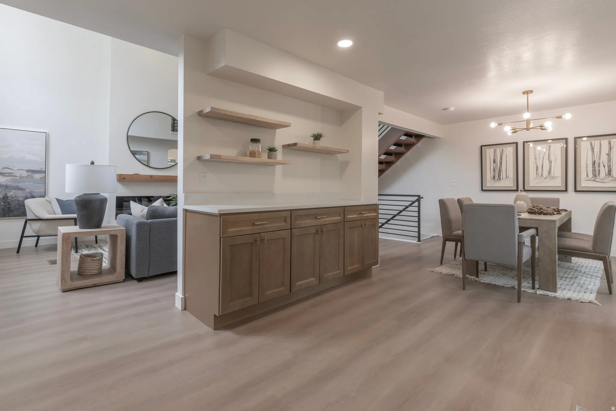 Wood-finish flooring throughout, featuring a built-in cabinet with a light-toned countertop and floating shelves