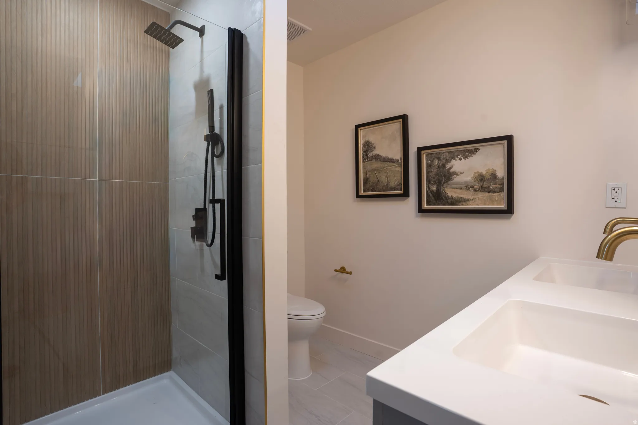 Walk-in shower with vertical ribbed wall tile, matte black shower fixtures, and a glass enclosure