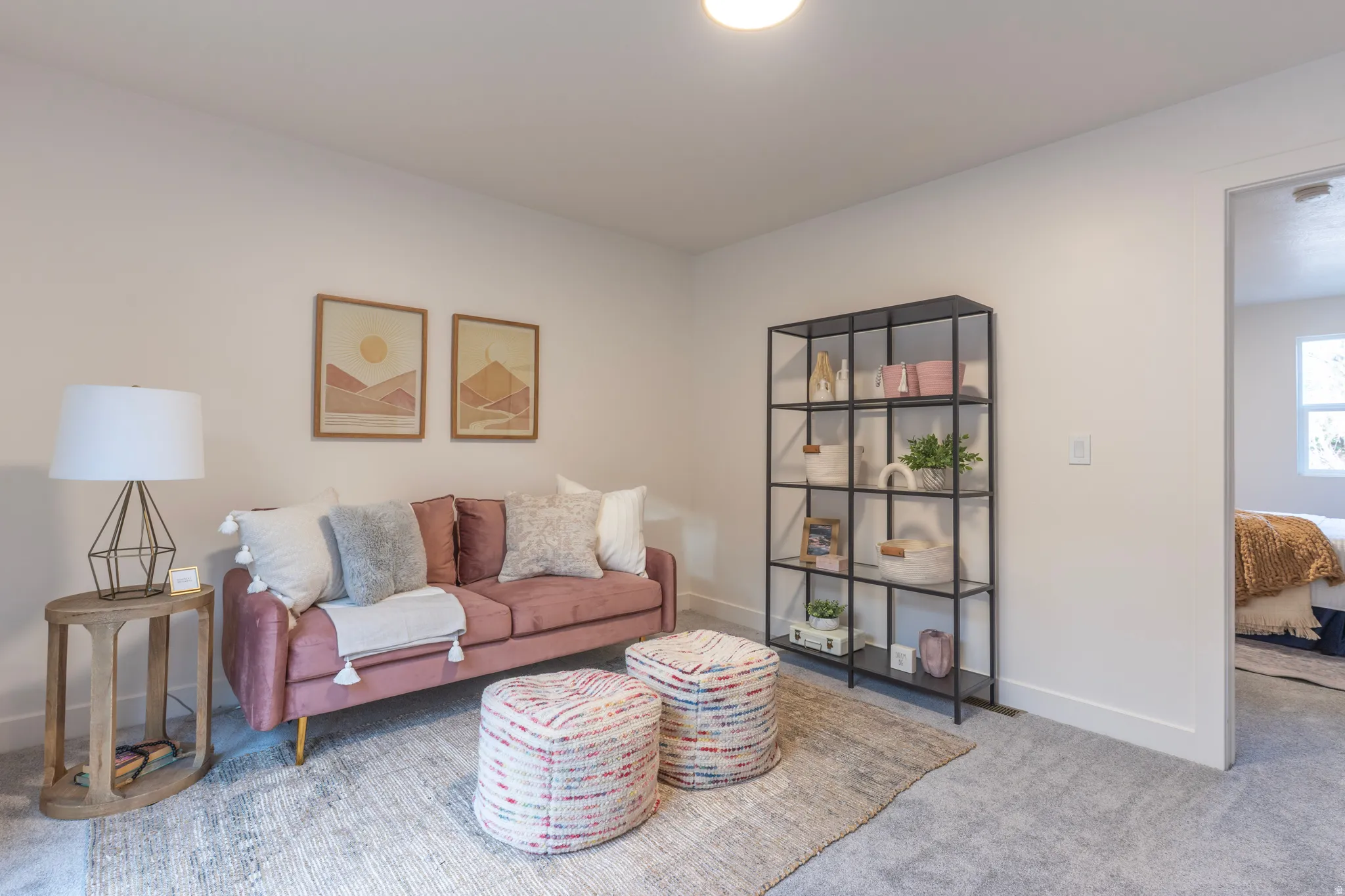 Carpeted flooring throughout, recessed ceiling lighting, built-in shelving unit, and a doorway leading to another room