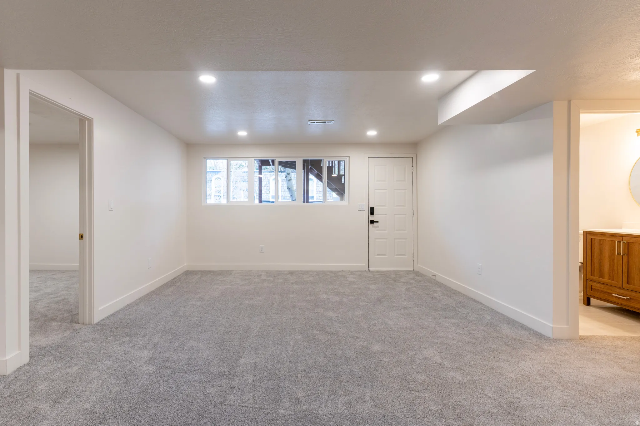 Recessed lighting, light gray carpeting, and white walls