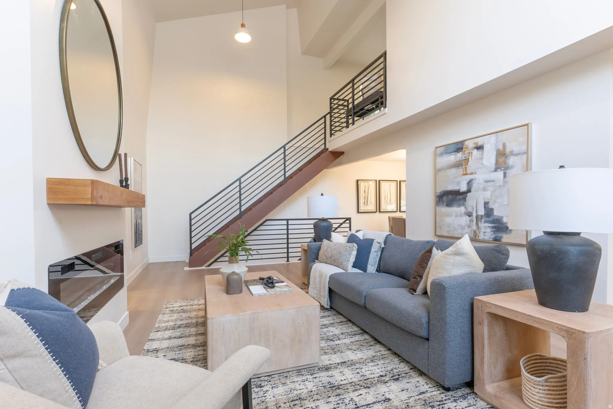 Soaring ceiling in the living area, featuring a contemporary fireplace with a floating wood mantle