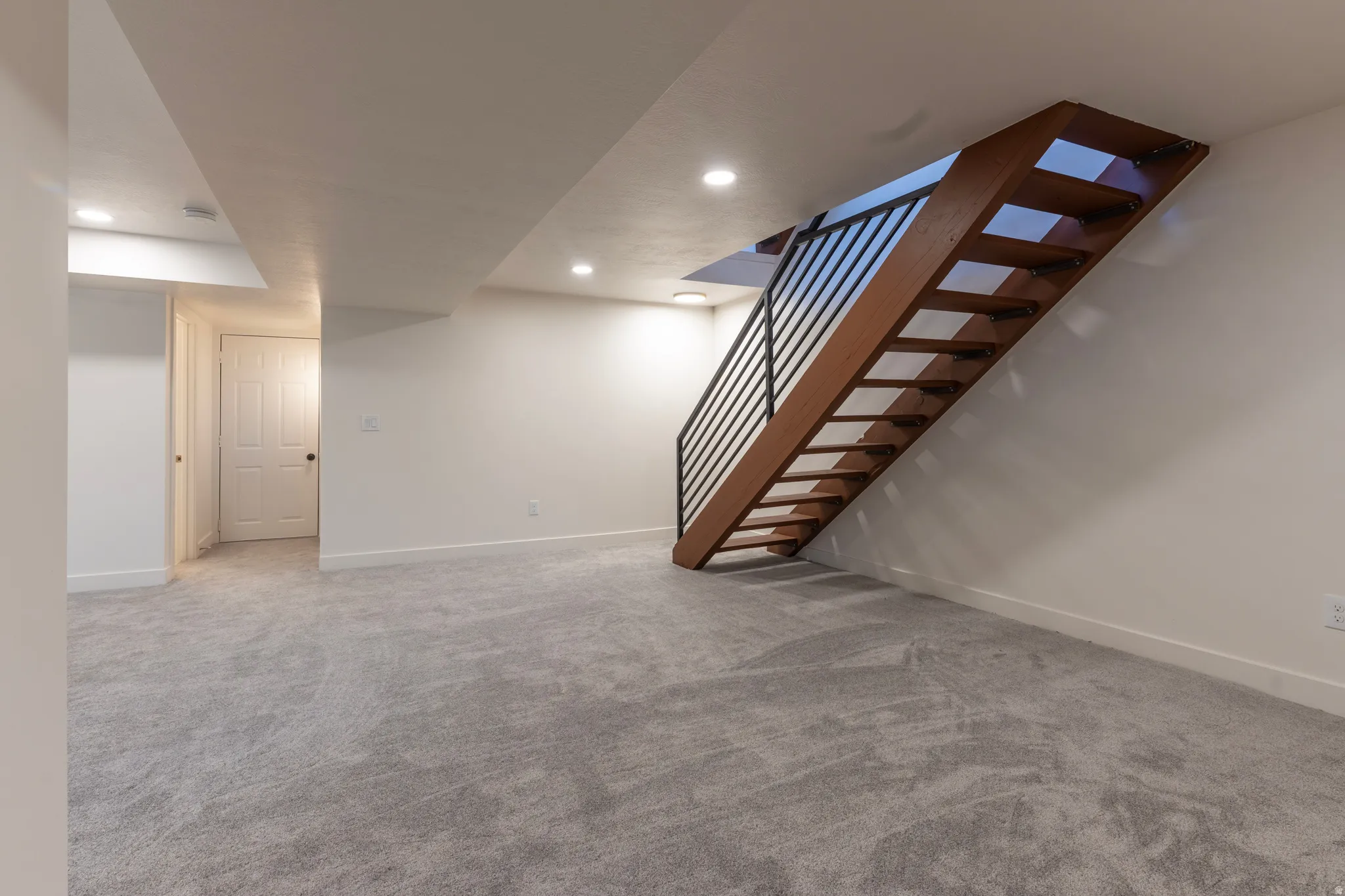 Open tread staircase with wood-finish risers and metal balusters