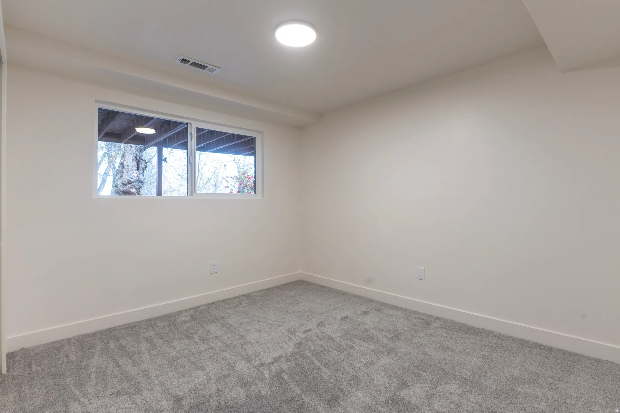 Windowed room featuring wall-to-wall carpeting and recessed ceiling lighting