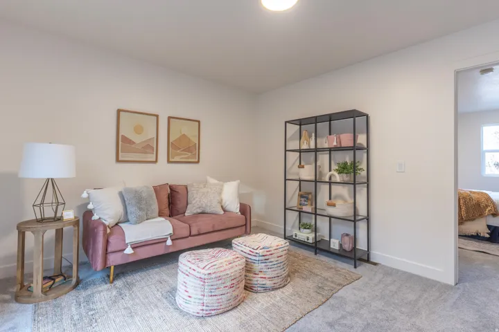 Carpeted flooring throughout, recessed ceiling lighting, built-in shelving unit, and a doorway leading to another room