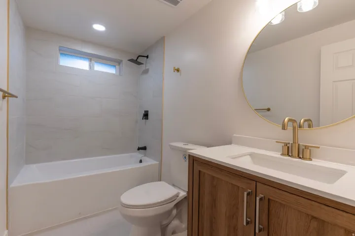 Wood-finish vanity with a white countertop and undermount sink