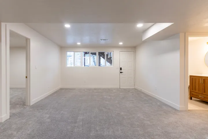 Recessed lighting, light gray carpeting, and white walls