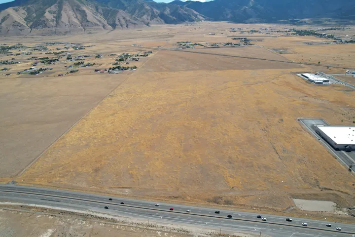 Expansive undeveloped land featuring a highway frontage and mountain backdrop