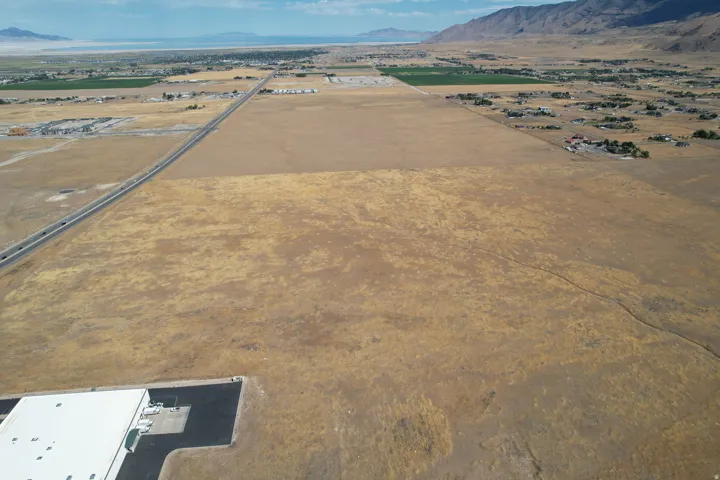Expansive open land with a distant mountain range and a large body of water