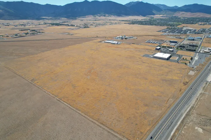 Expansive undeveloped land featuring a highway frontage and prominent mountain backdrop