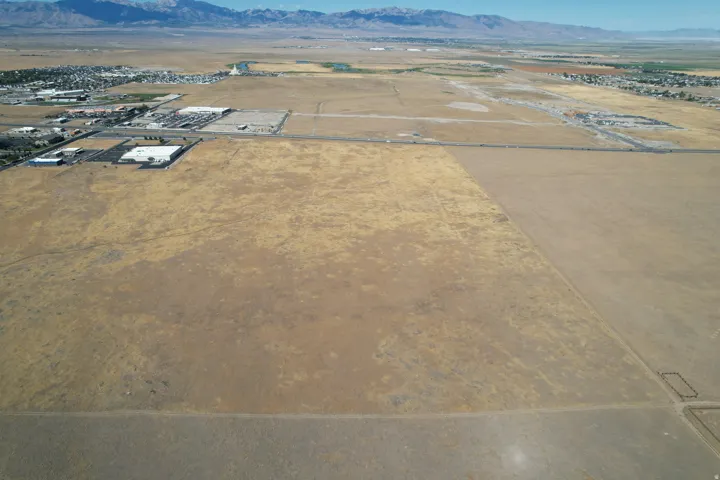Expansive land parcel with surrounding commercial structures and distant mountain range
