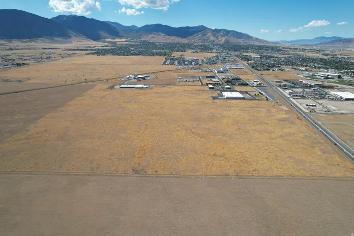 Expansive land parcel with surrounding commercial structures and a multi-lane highway